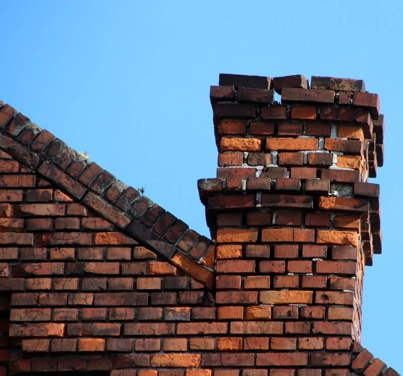 Damaged chimney on an Laguna Beach home showing cracks and missing mortar